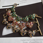 Heart bracelet with pink and green gemstone heart charms, gold-tone chain links
