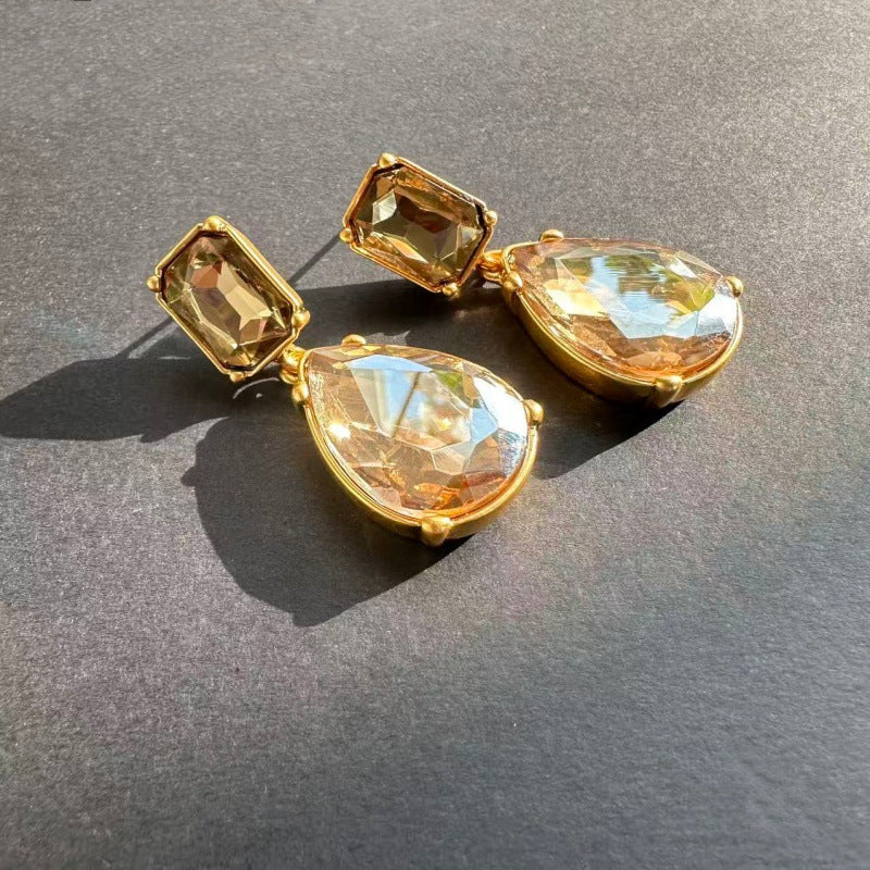 Teardrop-cut crystal stud earrings with champagne pear teardrop drops and golden square tops, gold tone