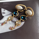 Long crystal drop earrings in gold with dark blue, champagne, and small pink crystals