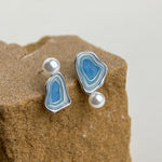Asymmetric blue enamel drop earrings with white pearls on silver-tone settings