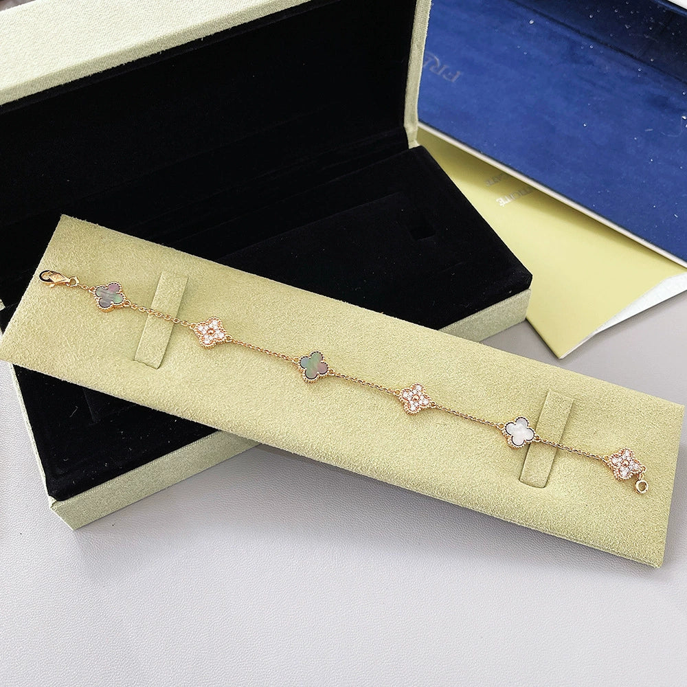 Goldfarbenes Armband mit Kleeblatt-Motiven, rosa Akzente auf der Kette, mit Verschluss