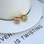 Gold square logo stud earrings with engraved geometric center detail