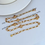 Interlocking logo chain necklace, gold-tone links with small clover drop charms and clasp