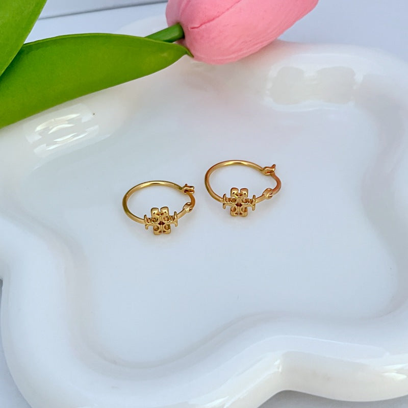 Gold hoop earrings with clover logo charm, hinged hoop detail