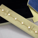 Goldfarbenes Armband mit weißen Kleeblatt-Anhängern