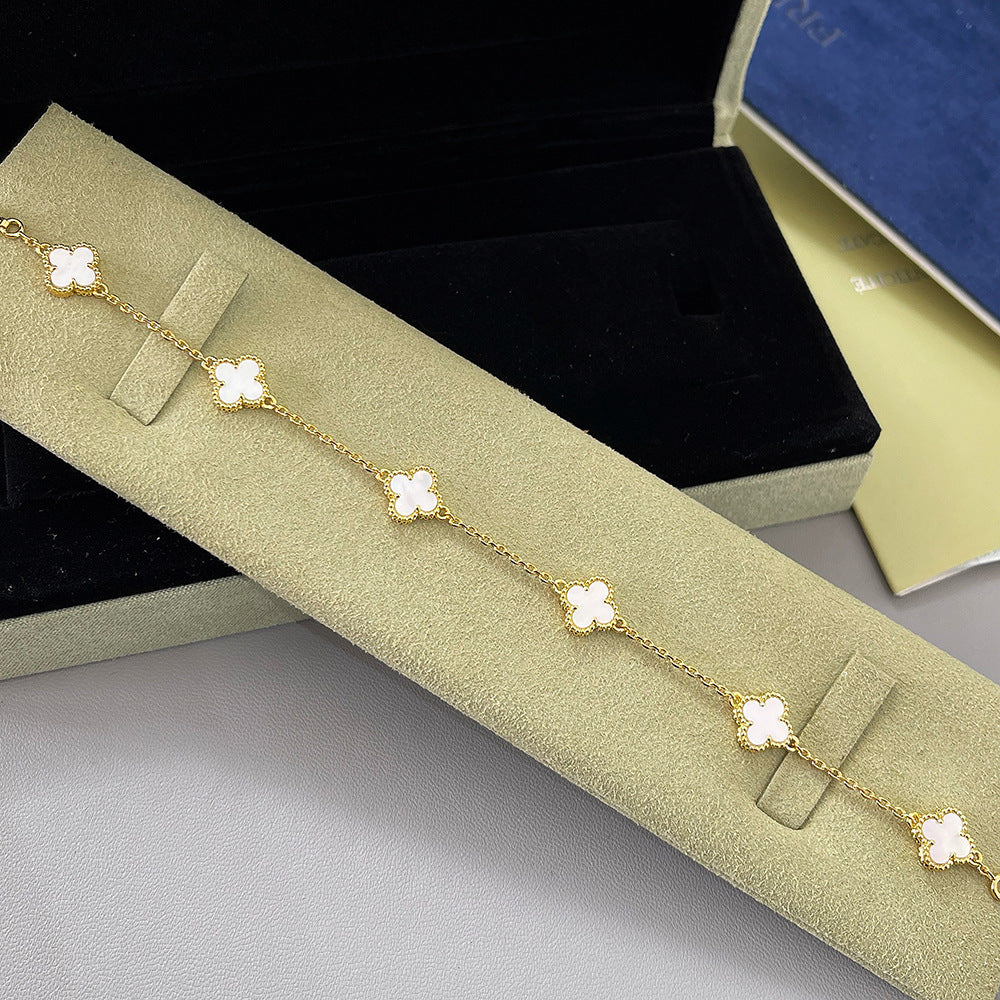 Goldfarbenes Armband mit weißen Kleeblatt-Anhängern
