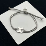 Gray woven adjustable drawstring bracelet with silver-tone clover enamel charm and coin tag