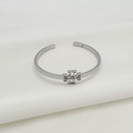 White gold open metal bangle with square logo openwork centerpiece