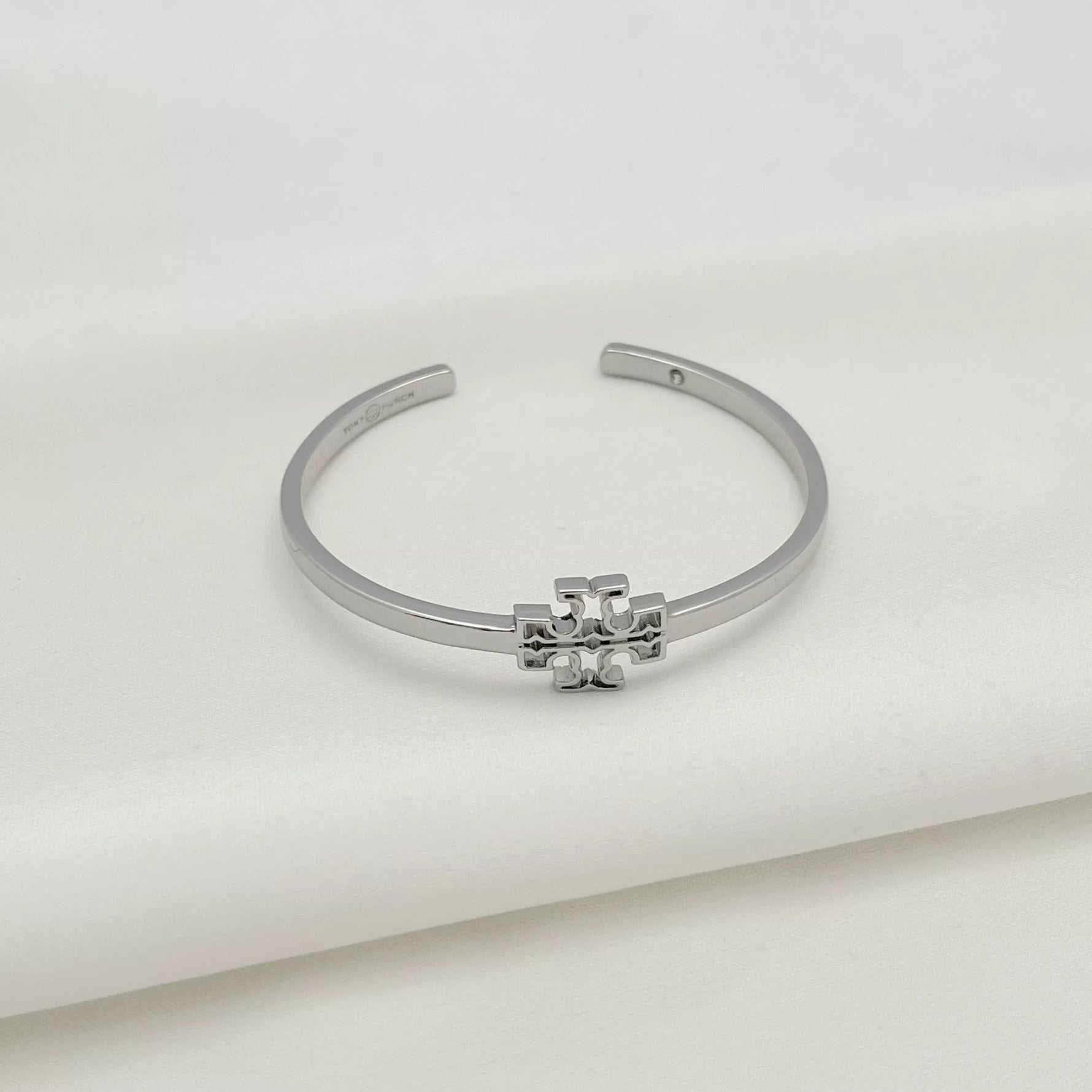 White gold open metal bangle with square logo openwork centerpiece