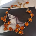Gold-tone link crystal necklace with orange oval and marquise faceted stones