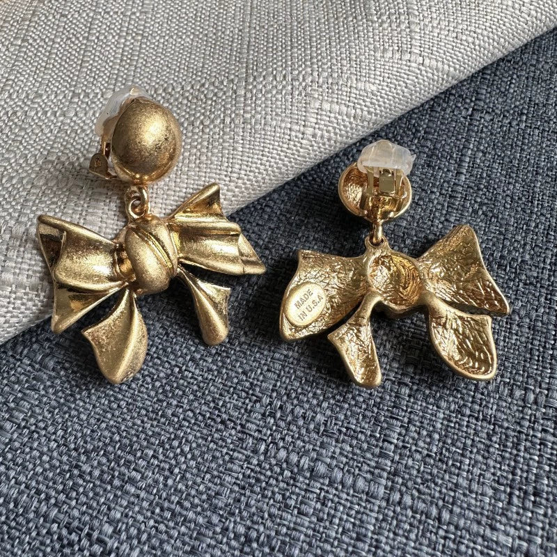 Gold-tone bow drop earrings with clasp backs and textured bow charms