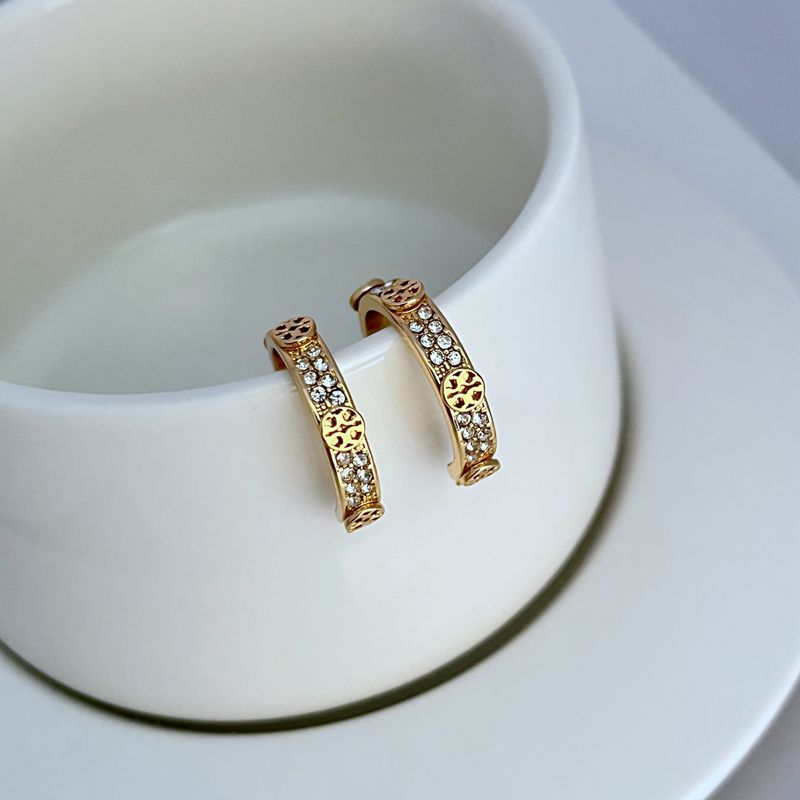 Gold hoop earrings, front view, with crystal pavé and round logo center