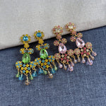 Rhinestone tassel clip-on earrings with green, blue, and gold floral drops