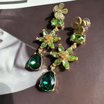 Green crystal floral drop earrings with gold-tone clover accents and teardrop dangles