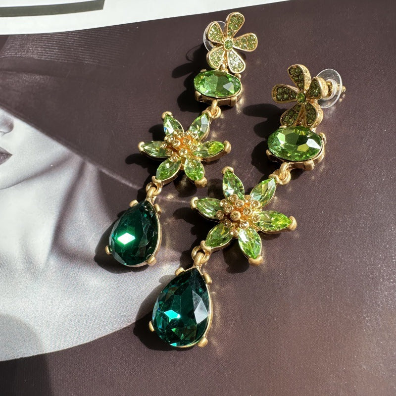Green crystal floral drop earrings with gold-tone clover accents and teardrop dangles