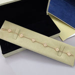 Rose-gold clover bracelet with white agate four-leaf links and chain clasp