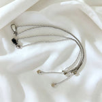 Silver-tone layered charm necklace with thin chains and small square charm pendants