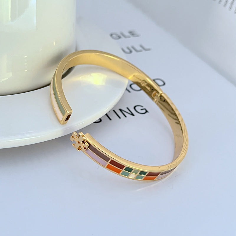 Gold-tone plaid enamel bangle with multicolor square pattern and hinge clasp hardware