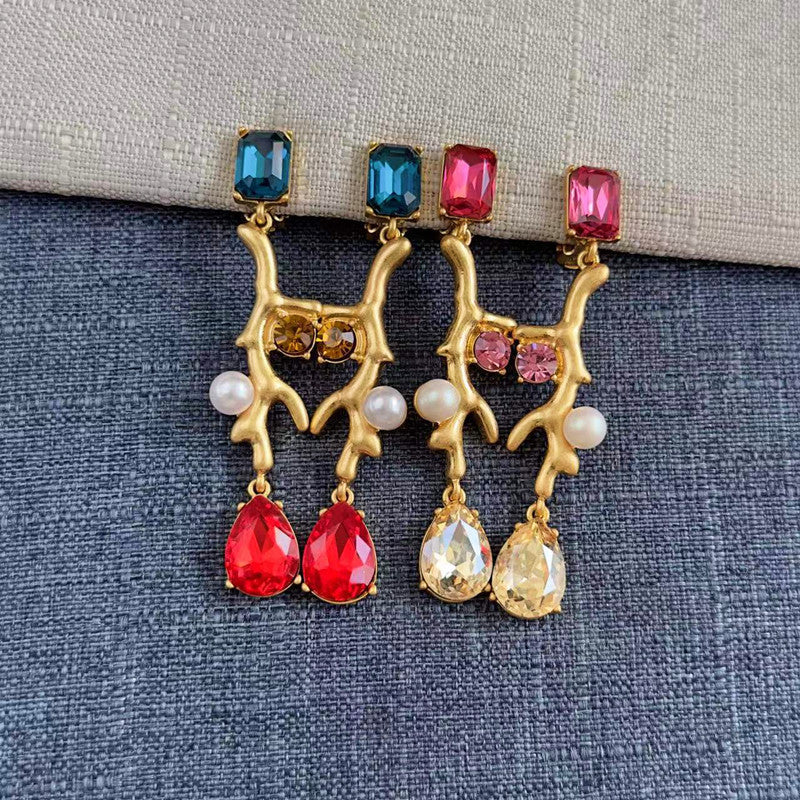 Clip-on earrings with gold branch design, blue and red crystals, and white pearls