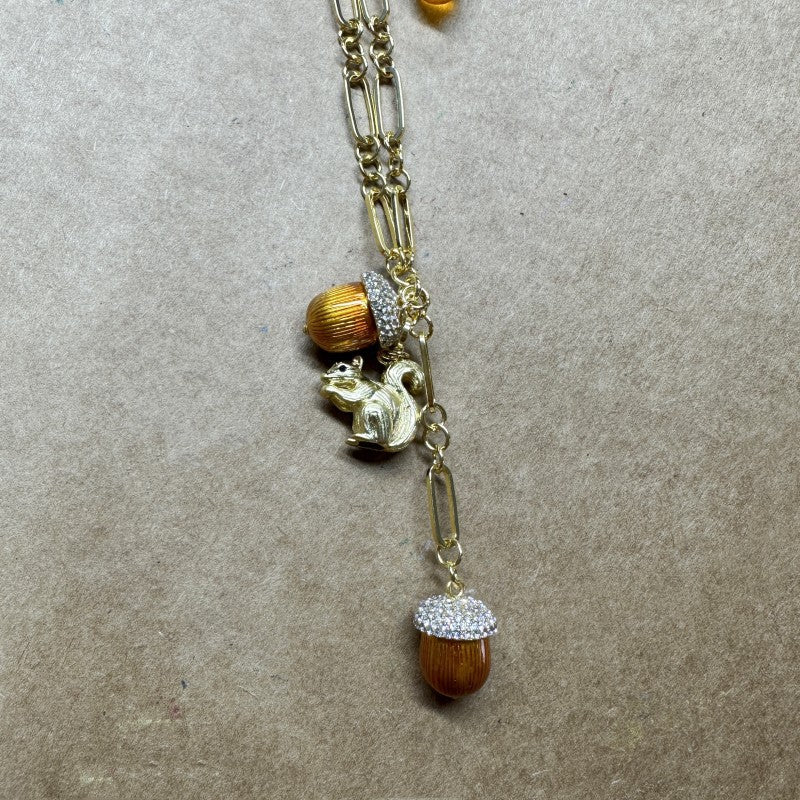 Gold pendant necklace with small squirrel charm, brown pinecone bead, and sparkle cap