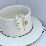 Gold-tone dangle hoop earrings with round white pearls and gold charm