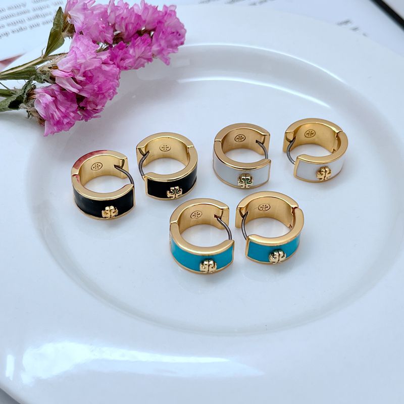 Gold-tone geometric hoop earrings with enamel inlays, including black and blue.