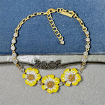 Enamel cherry blossom pendant necklace with yellow flowers and gold-tone chain with clear stones