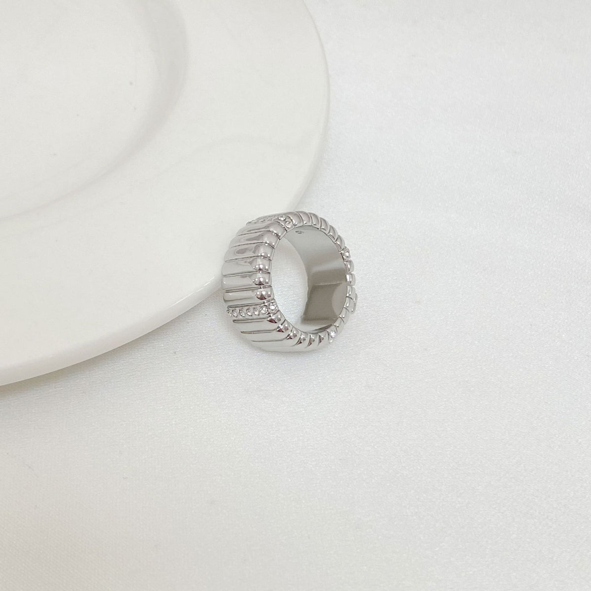 Silver-tone ring, side view with continuous rhinestone band around the top