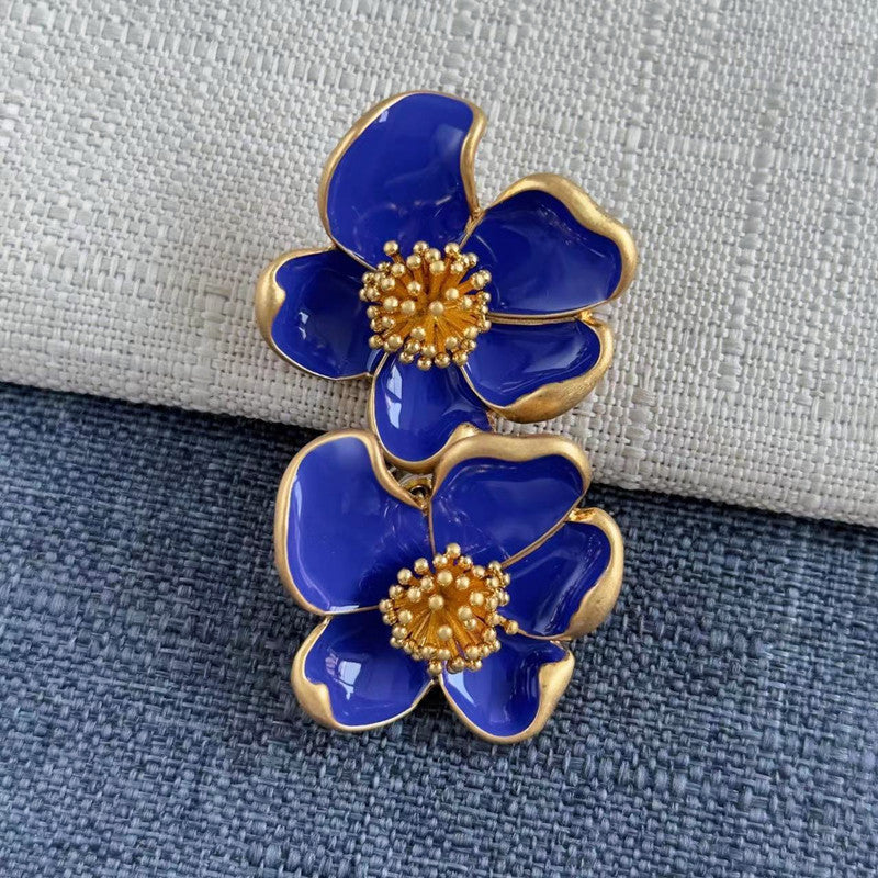 Deep blue enamel floral stud earrings with gold-tone petals and golden beaded details