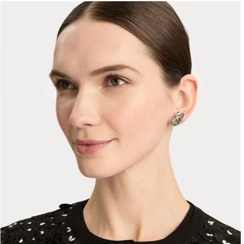 Looped teardrop earrings on model, gold tone with clear teardrop stone