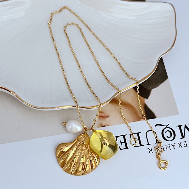 Gold-tone shell pendant necklace with yellow acrylic bead and white freshwater-style pearl