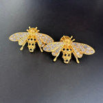 Gold-tone bee earrings with crystal pavé wings and dark enamel stripes