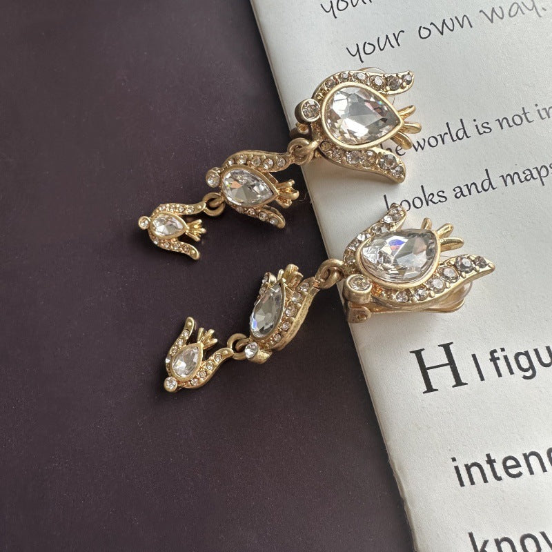 Gold-tone floral zircon drop earrings with clear oval stones and chain links