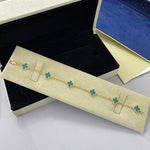 Gold tone bracelet with teal green clover charms on a fine chain, four-leaf design