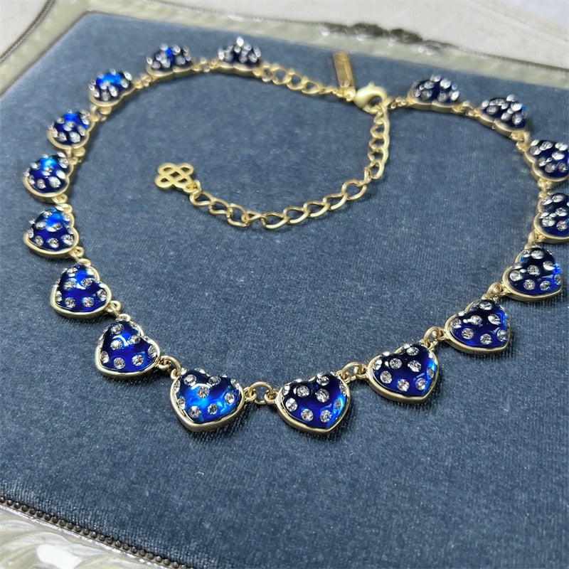 Blue rhinestone heart necklace with gold-tone links and faceted heart charms