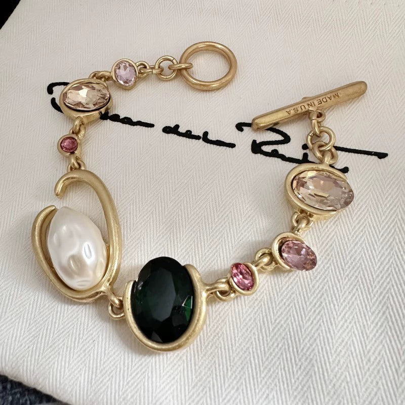 O-ring crystal pearl bracelet, gold tone with dark green oval center stone, pink crystals, pearl