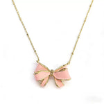 Gold-tone bow pendant necklace with pink enamel and chain links