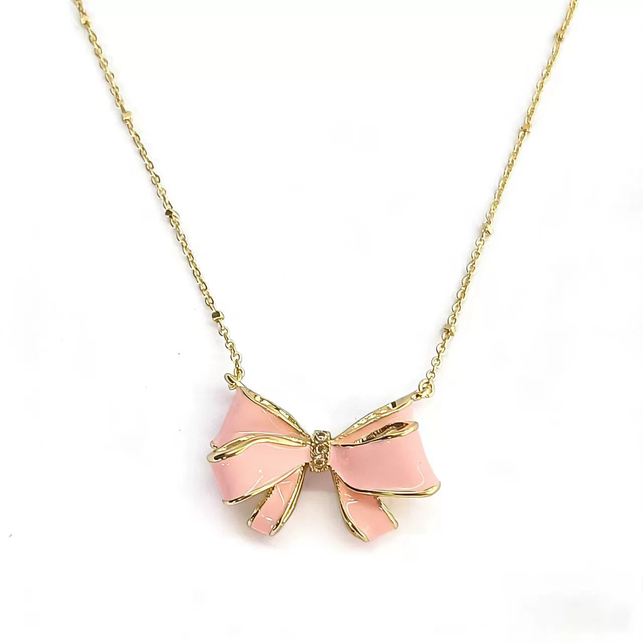 Gold-tone bow pendant necklace with pink enamel and chain links