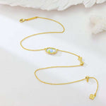 Gold bow pendant necklace with blue rose-print oval centerpiece