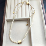 Pearl drawstring necklace with gold square tag and cube bead end caps