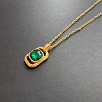 Gold-tone hammered square pendant necklace with faceted green gemstone