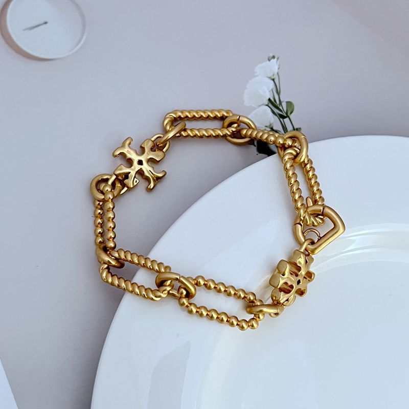 Gold square-logo chain bracelet with chunky links and layered charm accents