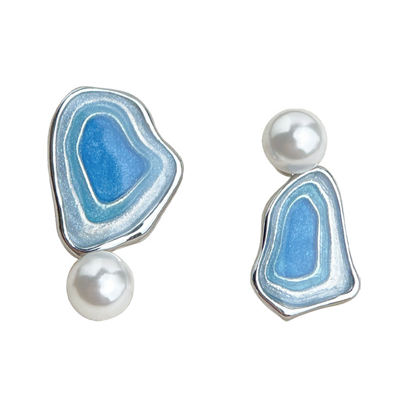 Close-up blue enamel triangle drop earrings with white pearl drops, silver-tone finish