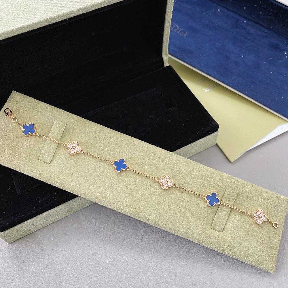 Goldfarbenes Armband mit abwechselnden Kleeblatt-Motiven in Blau und Rosa, mit Verschluss