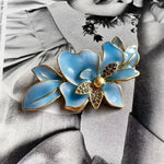 Blue enamel flower brooch with gold edges and rhinestone centers