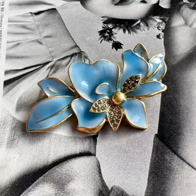Blue enamel flower brooch with gold edges and rhinestone centers