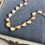 Heart-shaped necklace with gold chain and pearl white heart charms
