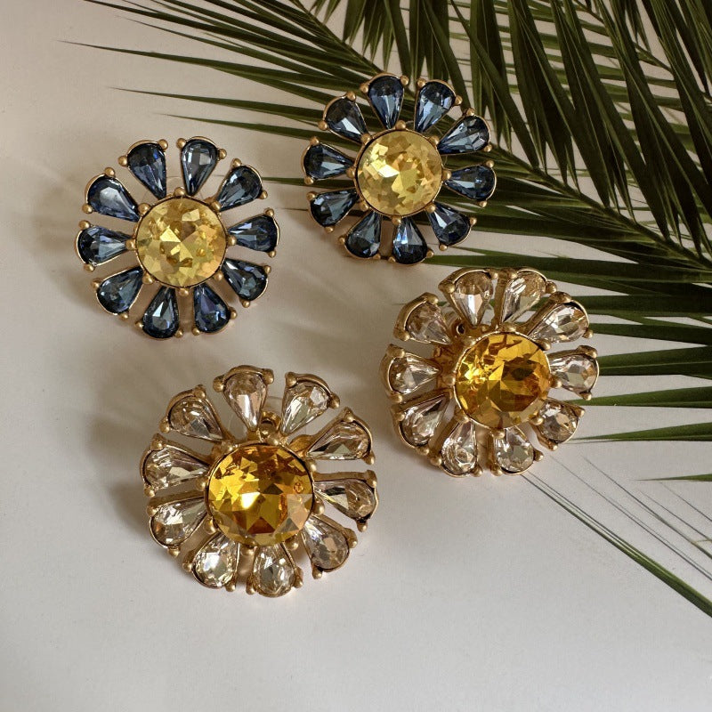 Sunburst flower stud earrings with blue teardrop stones and pale yellow center