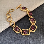 Square crystal toggle bracelet with deep purple stones and gold toggle clasp