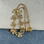 Four-leaf clover necklace with green textured flowers, red ladybug charm, gold links
